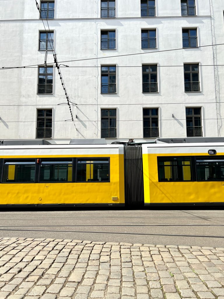 Street photography in Berlin. Photo of a tram in a street. Colourful yellow photo.